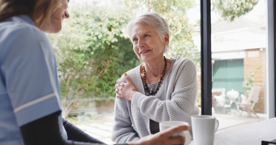 Woman consulting with a physical therapist regarding arthritis pain in her shoulder. | ProFysio Physical Therapy
