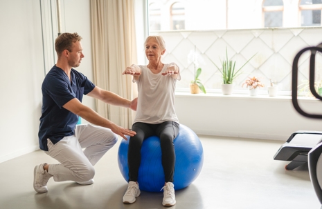 Older woman doing physical therapy exercises with a physical therapist.