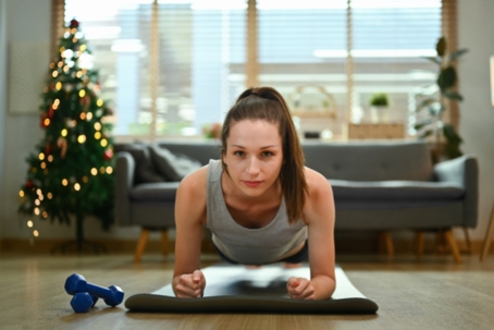 Woman doing yoga in her living room during the holiday season. | ProFysio Physical Therapy