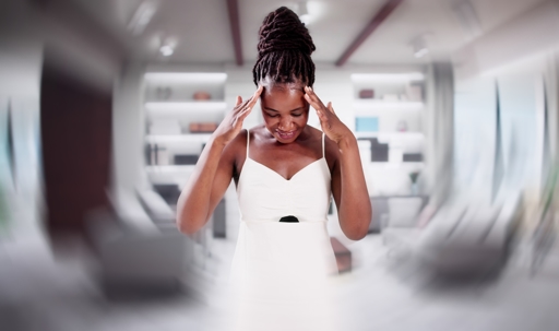 Woman with vertigo holding her head as the room seems to spin around her during a dizzy spell. | ProFysio Physical Therapy