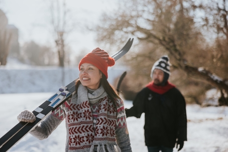 Couple bundled up in winter holiday attire enjoying a fun day on the ski slopes. | ProFysio Physical Therapy