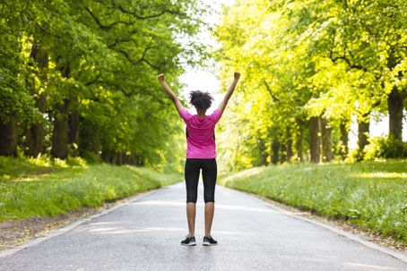 Woman excited to be outdoors getting exercise.
