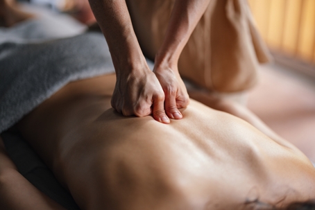Person receiving a massage with strong pressure that may cause mild discomfort.