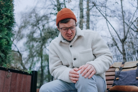Man rubbing his knee due to joint pain during chilly weather.